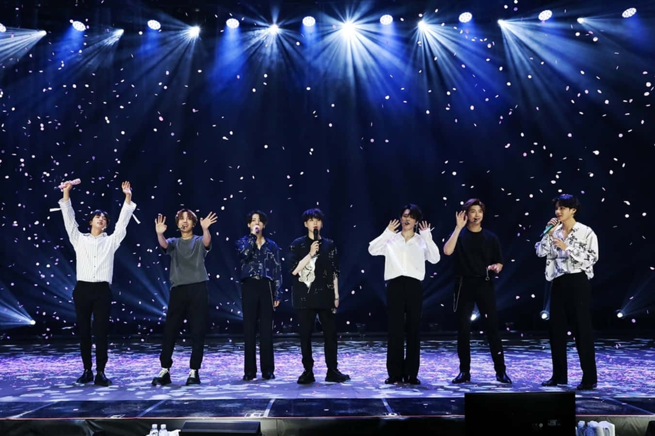 BTS performing live on stage in a dynamic concert Wallpaper