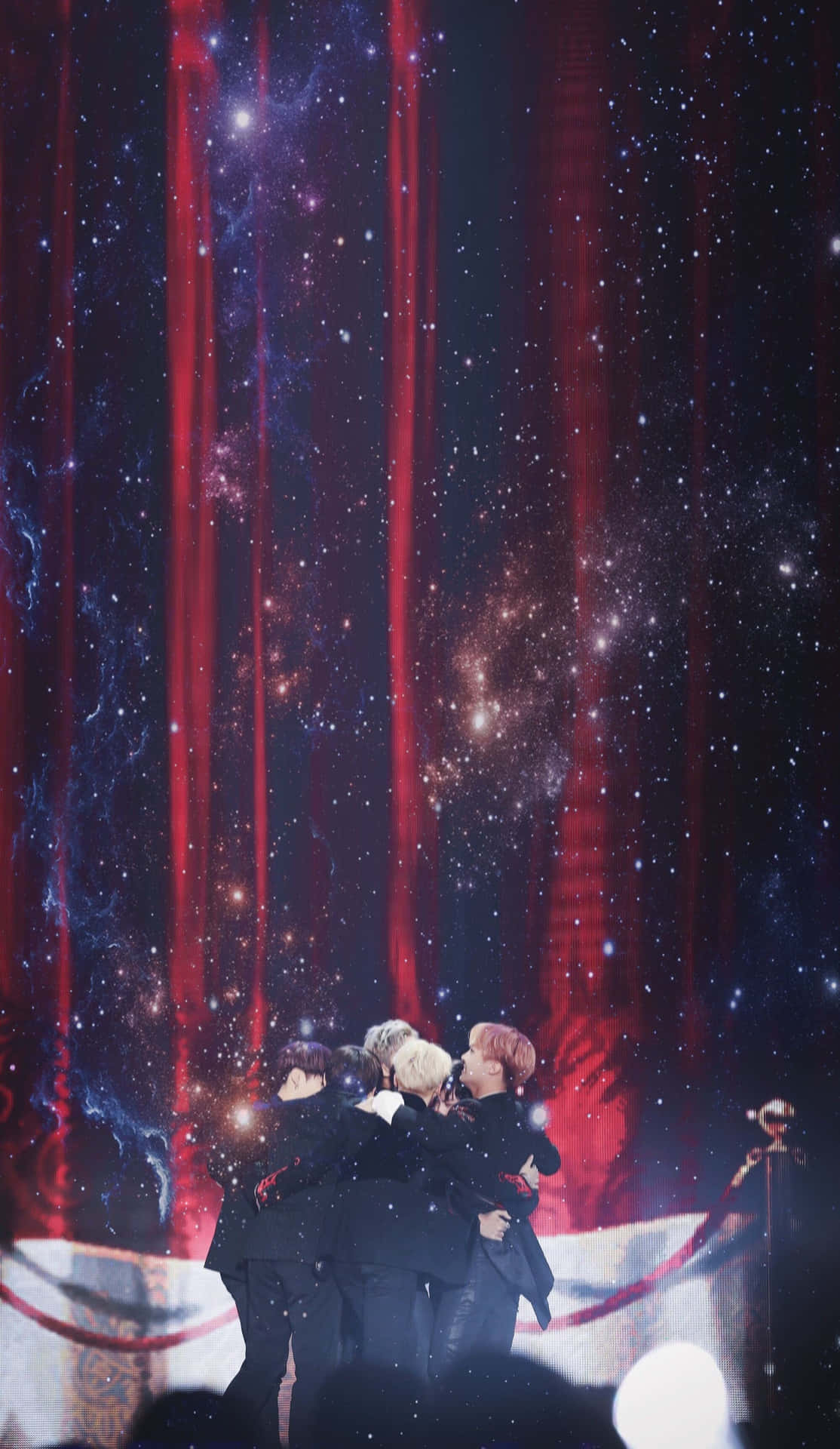 BTS performing live on stage during a concert Wallpaper