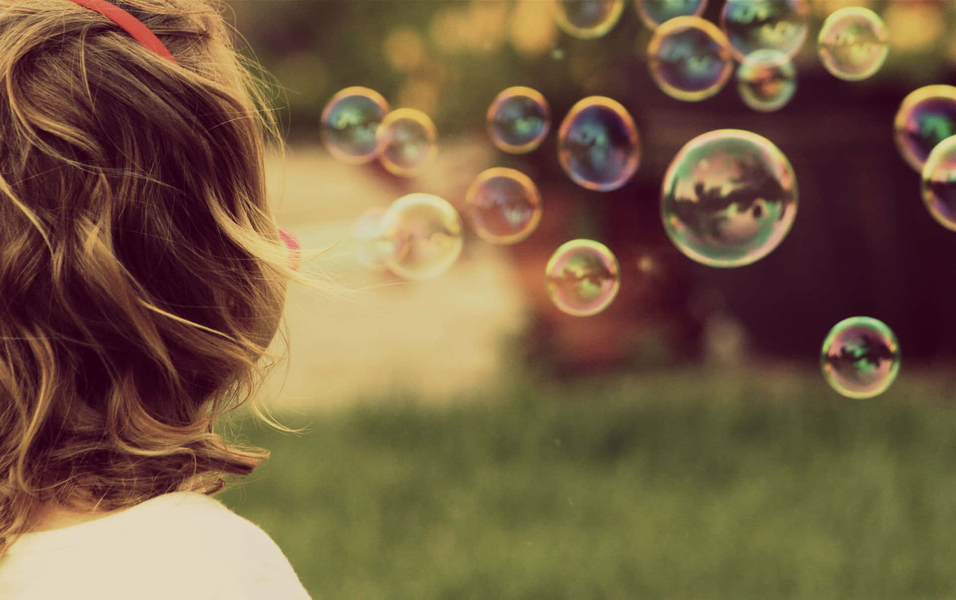 Fondode Burbujas Con Una Chica Soplando Burbujas.