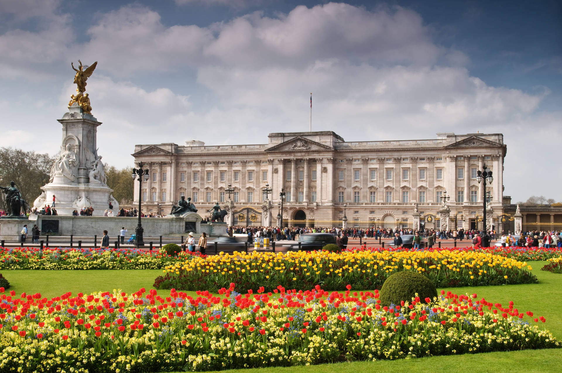 Serene view of Buckingham Palace with a blooming garden. Wallpaper