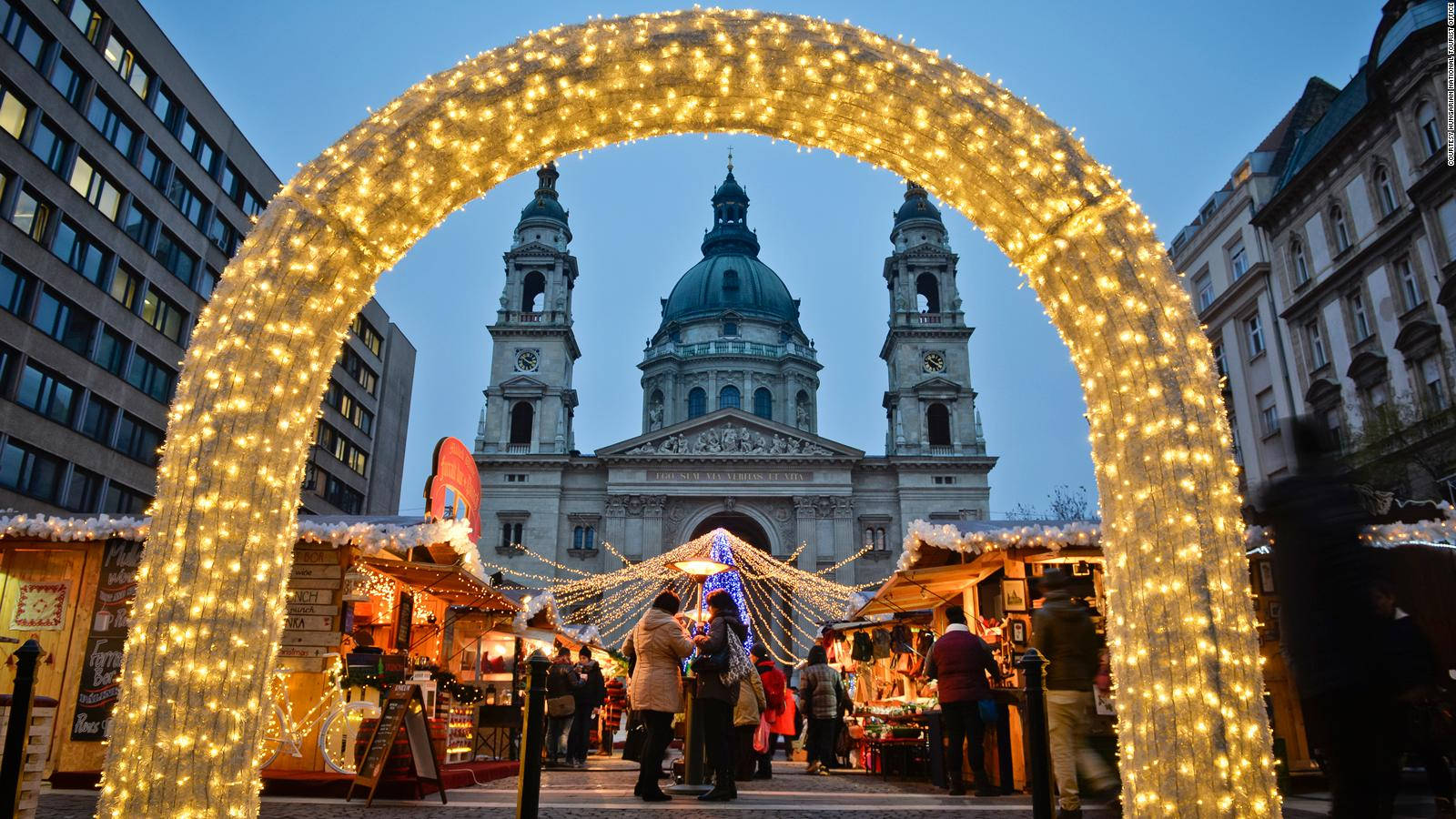 a christmas market with lights in front of a church Wallpaper