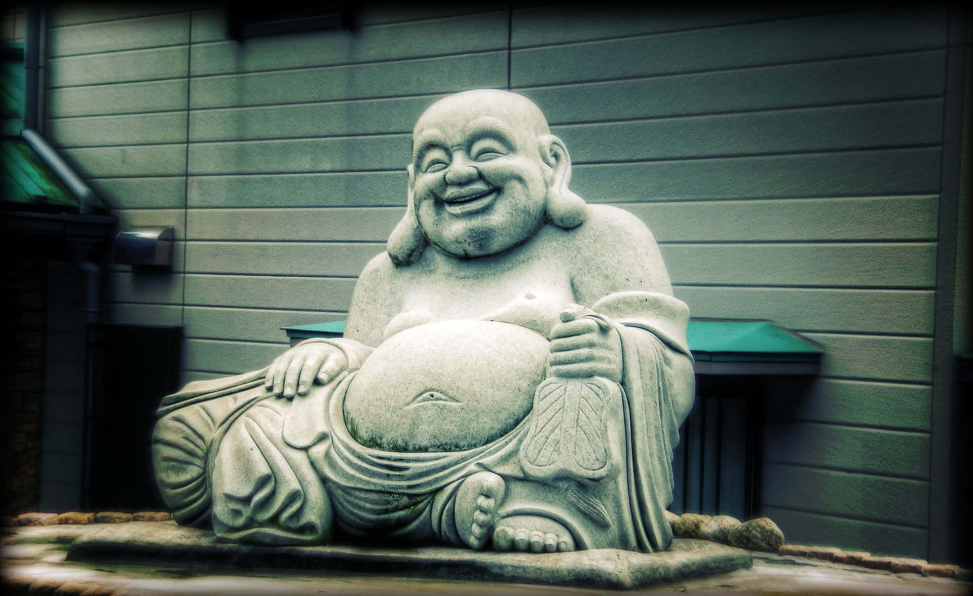 A Buddha Statue Sitting On A Rock