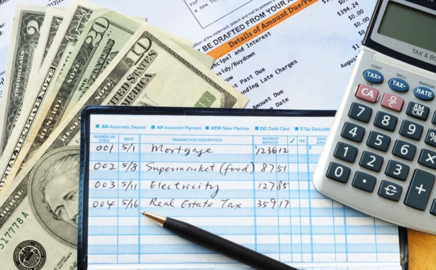 A Calculator, Pen And Money On A Desk