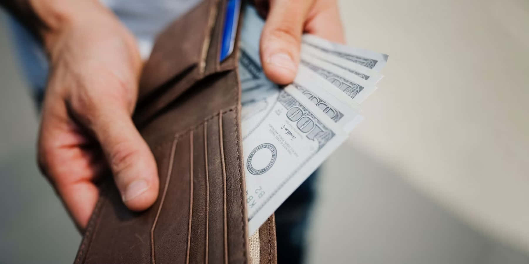 A Man Holding Money In A Wallet