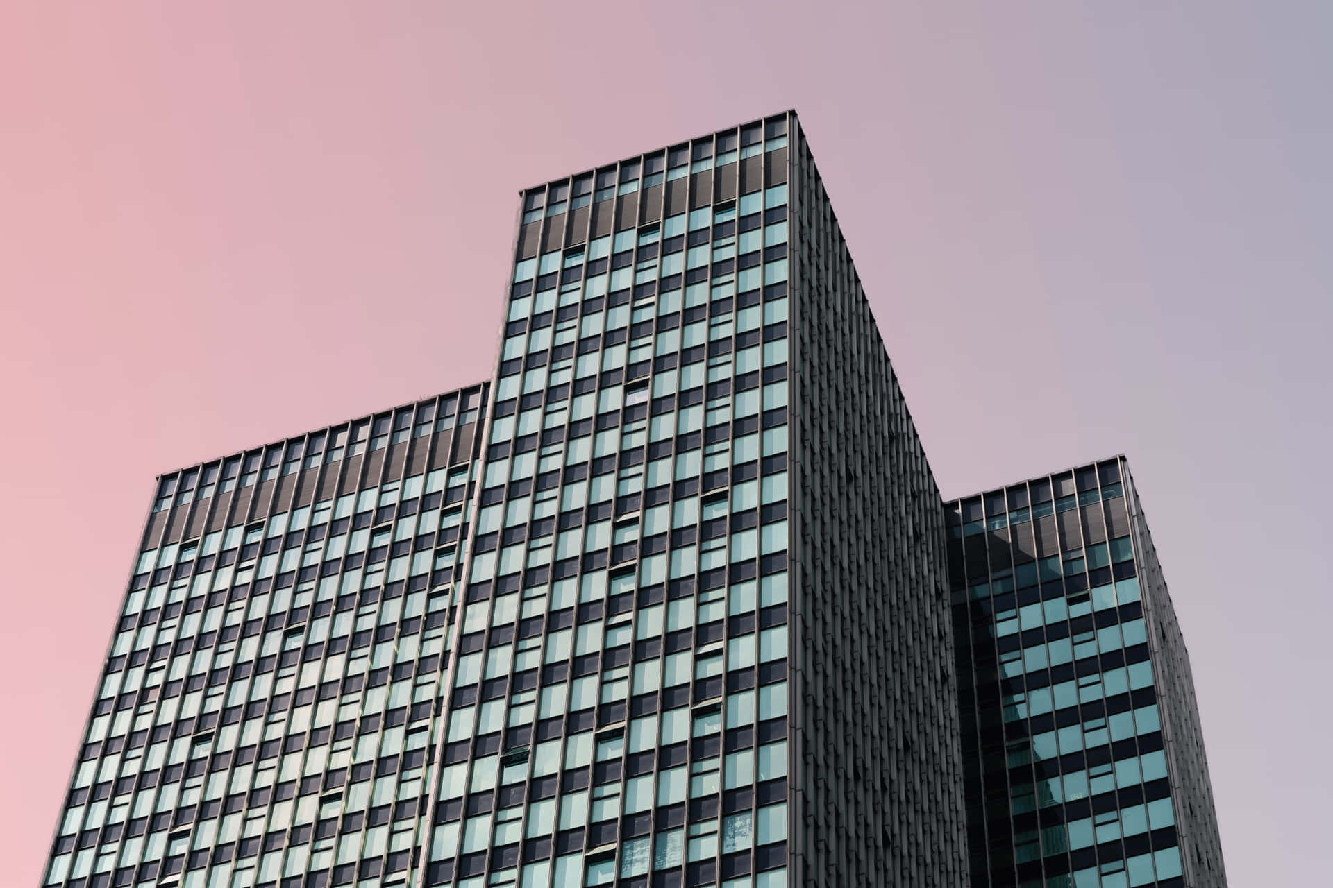 A Building With Windows Against A Pink Sky