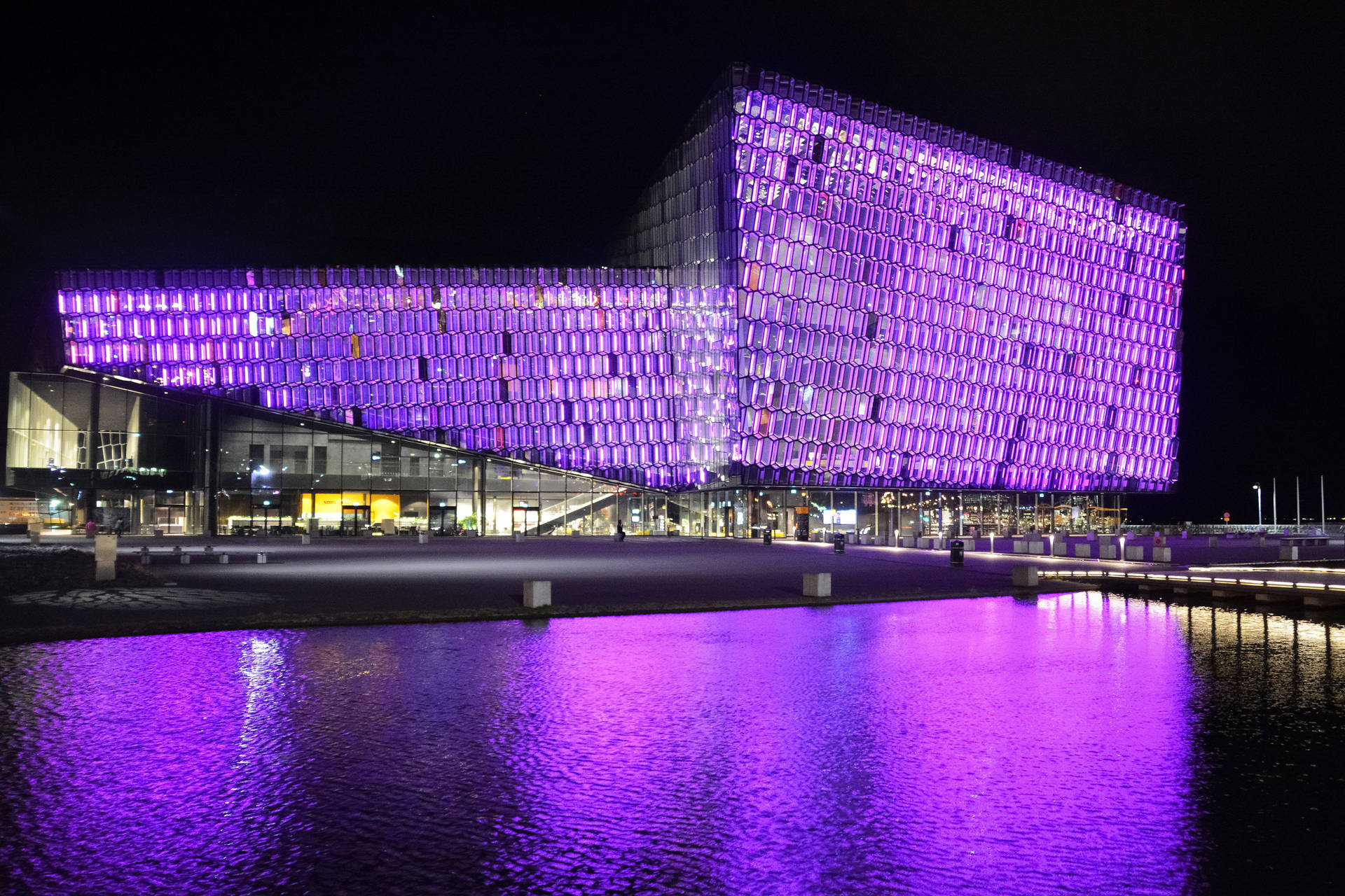 Building With Light Purple Lights By The Water Wallpaper