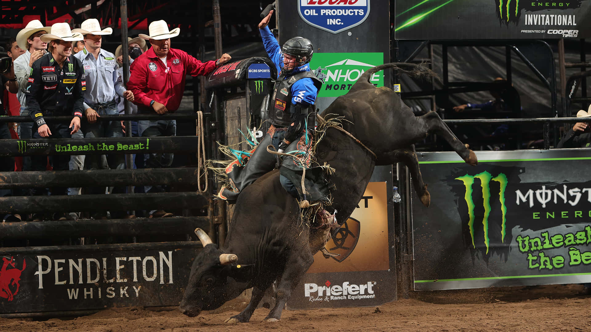 A Rodeo Rider Is Bucking His Bull In Front Of A Crowd