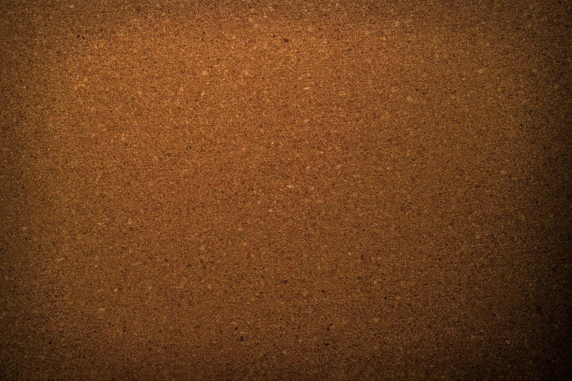 A Brown Cork Board With A Light Shining On It