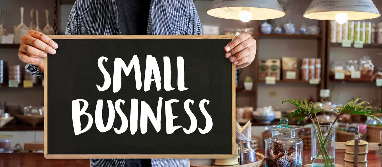 A Man Holding Up A Sign That Says Small Business