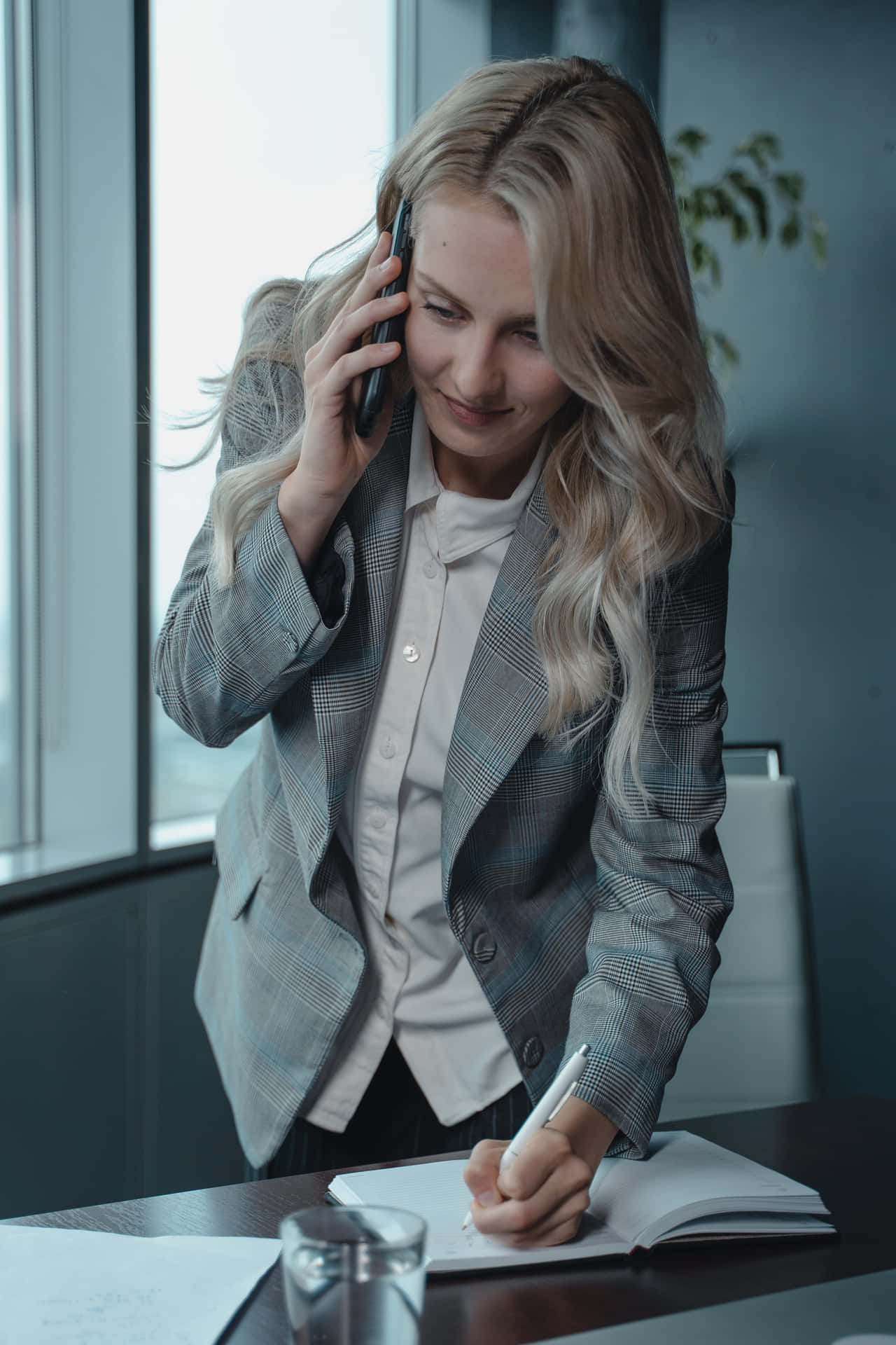 A Woman Is Talking On The Phone While Sitting At A Desk