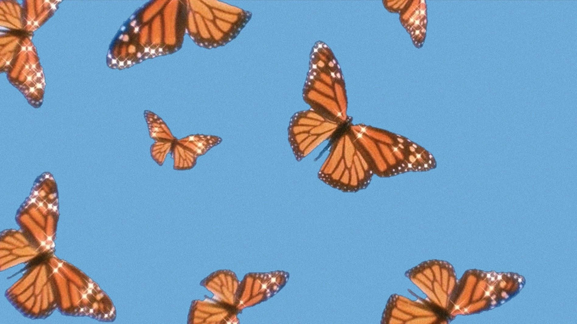 Nyd et afslappende øjeblik med en bærbar mens du ser sommerfugle glad flyve i haven. Wallpaper