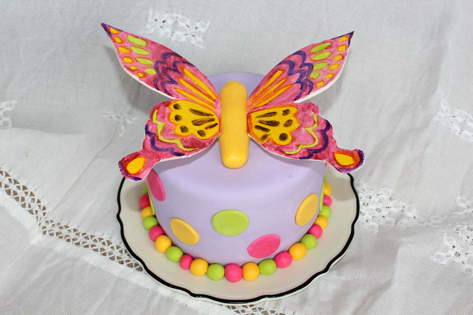 Delightful butterfly cake with colorful swirls and a cherry on top Wallpaper