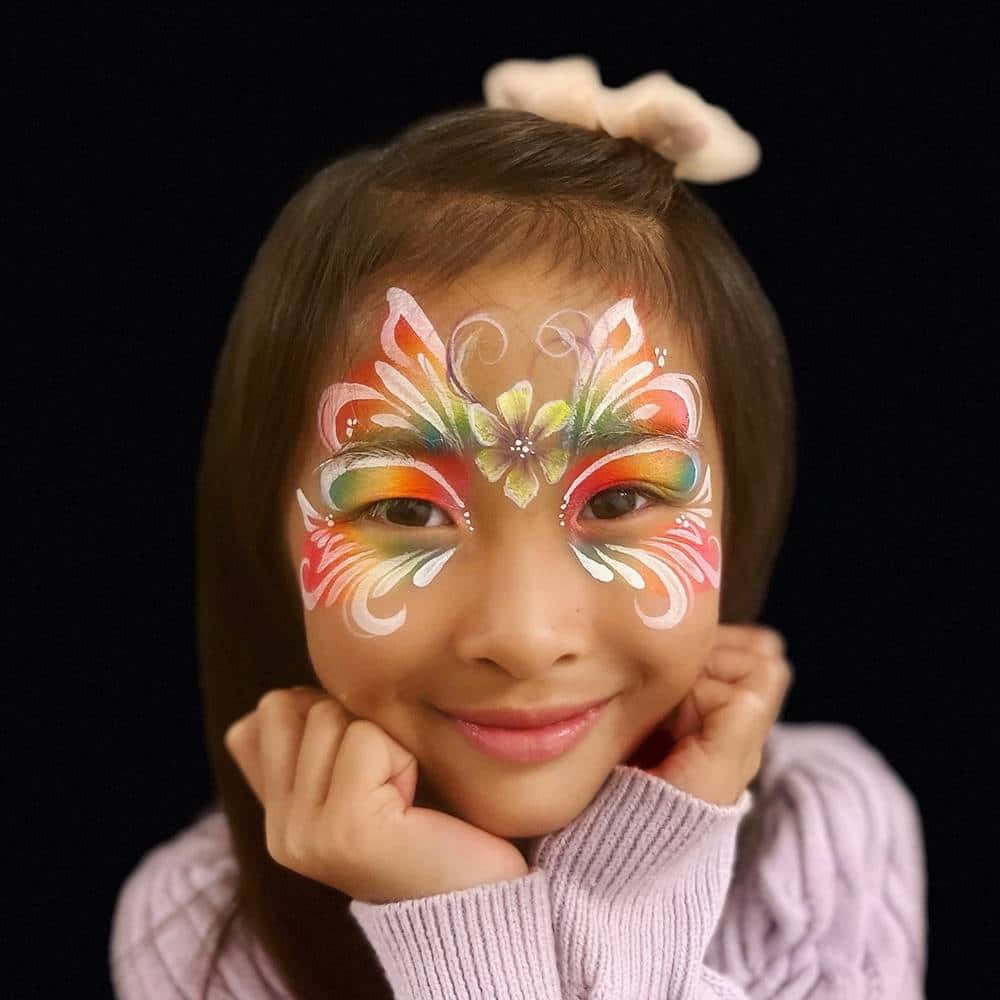 A young girl enjoying a beautiful butterfly face painting. Wallpaper