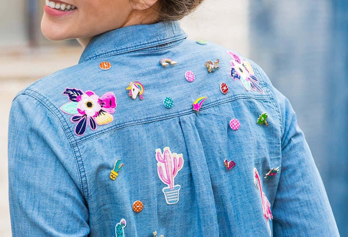 A Woman Wearing A Denim Jacket With Embroidered Flowers