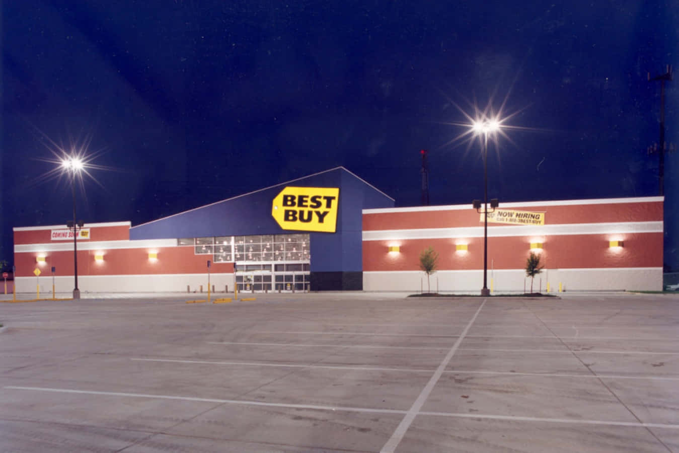 A Best Buy Store At Night With Lights On