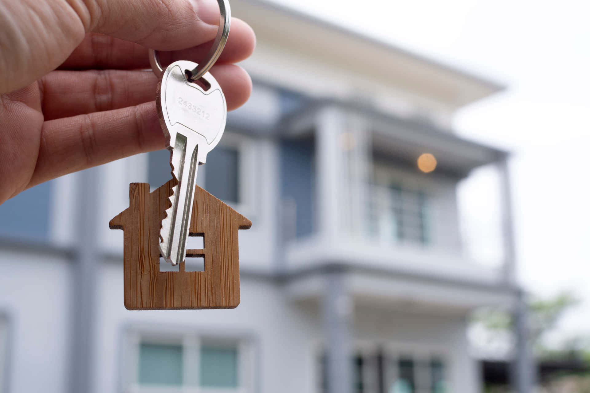 A Person Holding A Key To A House