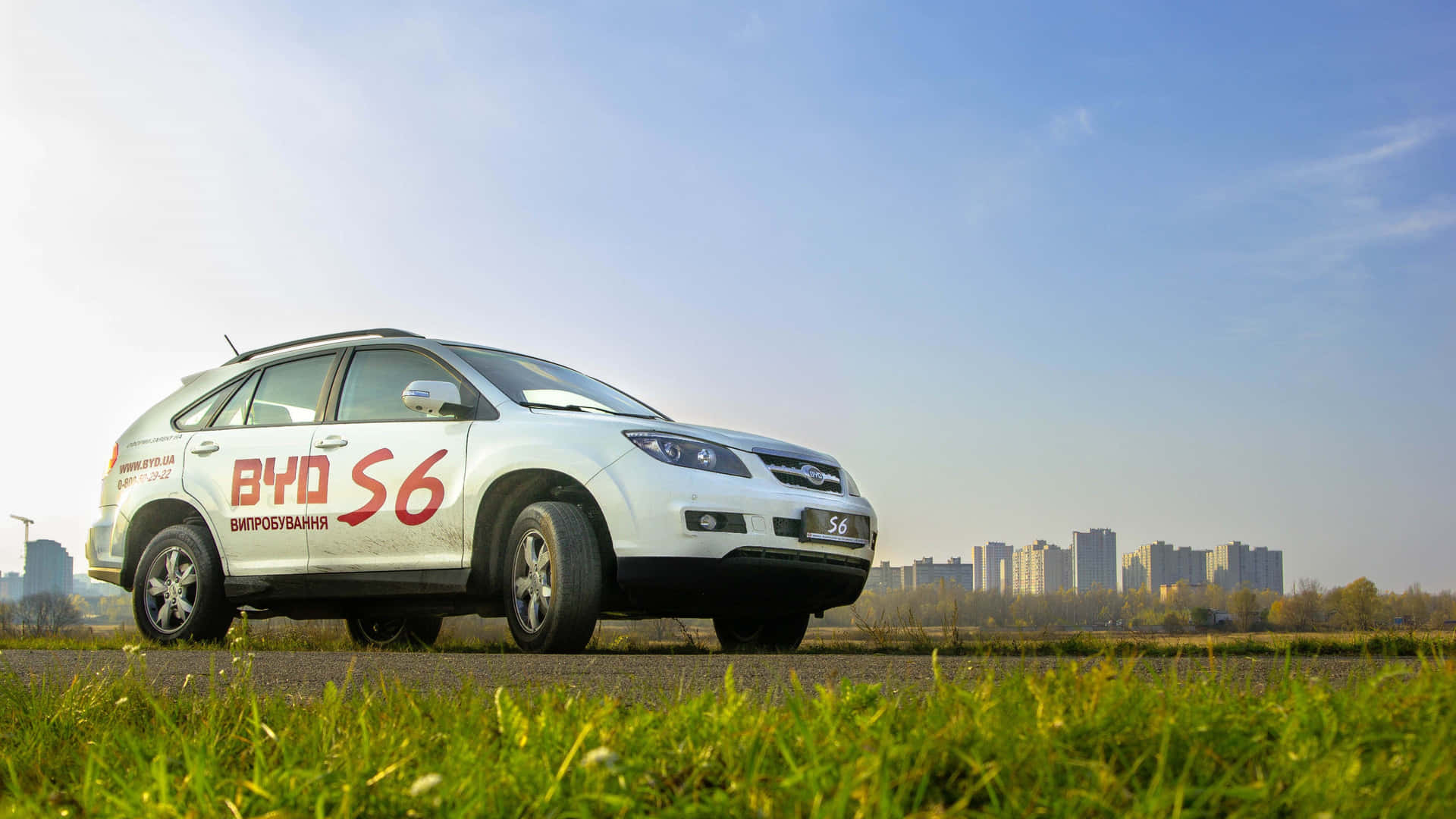 A stunning BYD electric vehicle parked on a picturesque street. Wallpaper