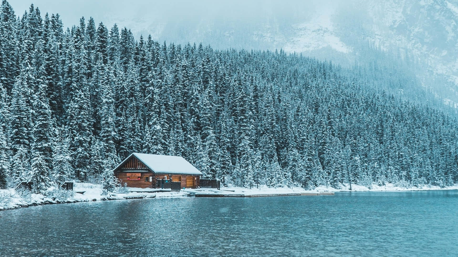 Cabin Snow Covered By The Lake Wallpaper