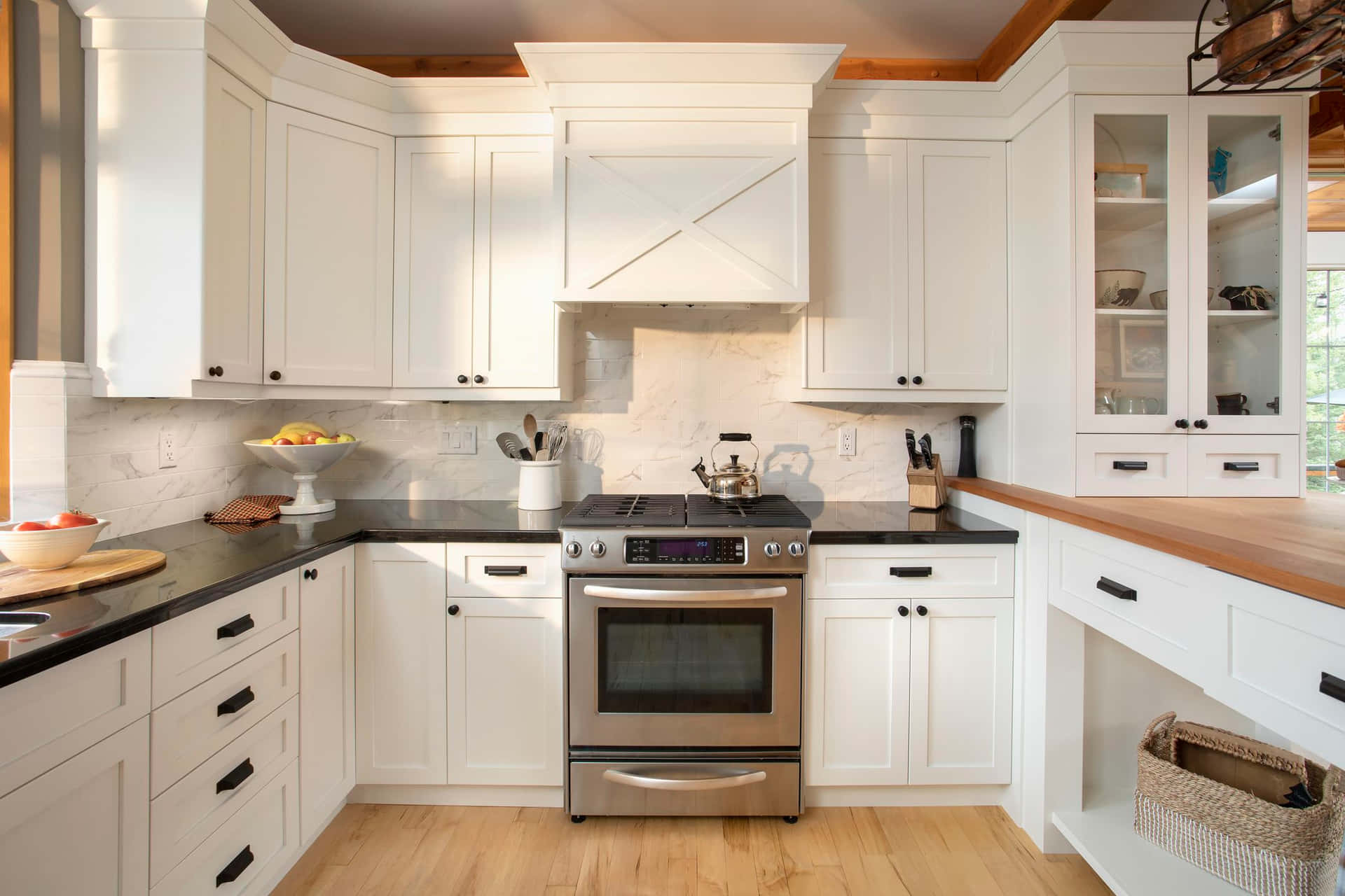 A Kitchen With White Cabinets And Black Counter Tops
