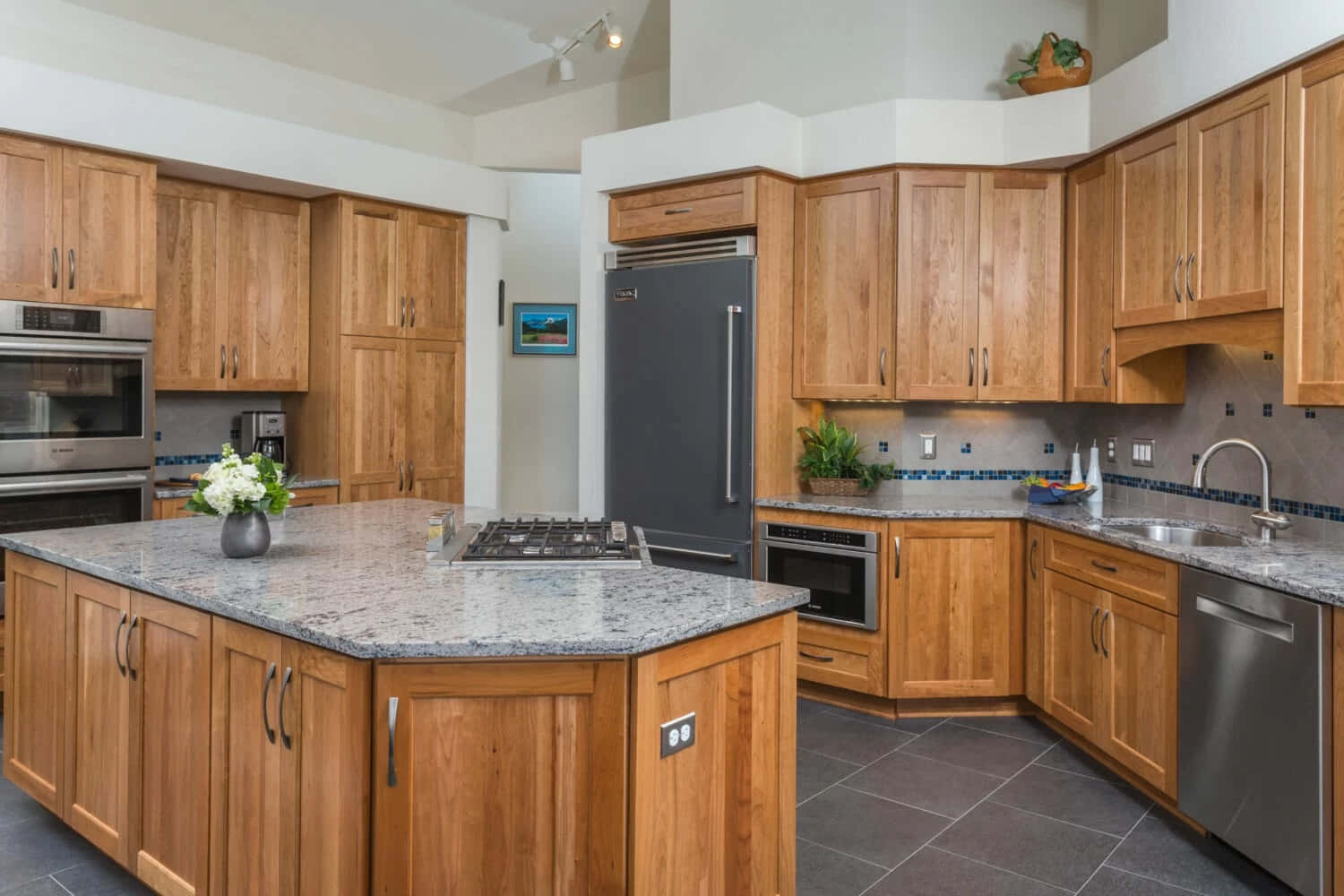 A Kitchen With Wood Cabinets And Granite Counter Tops
