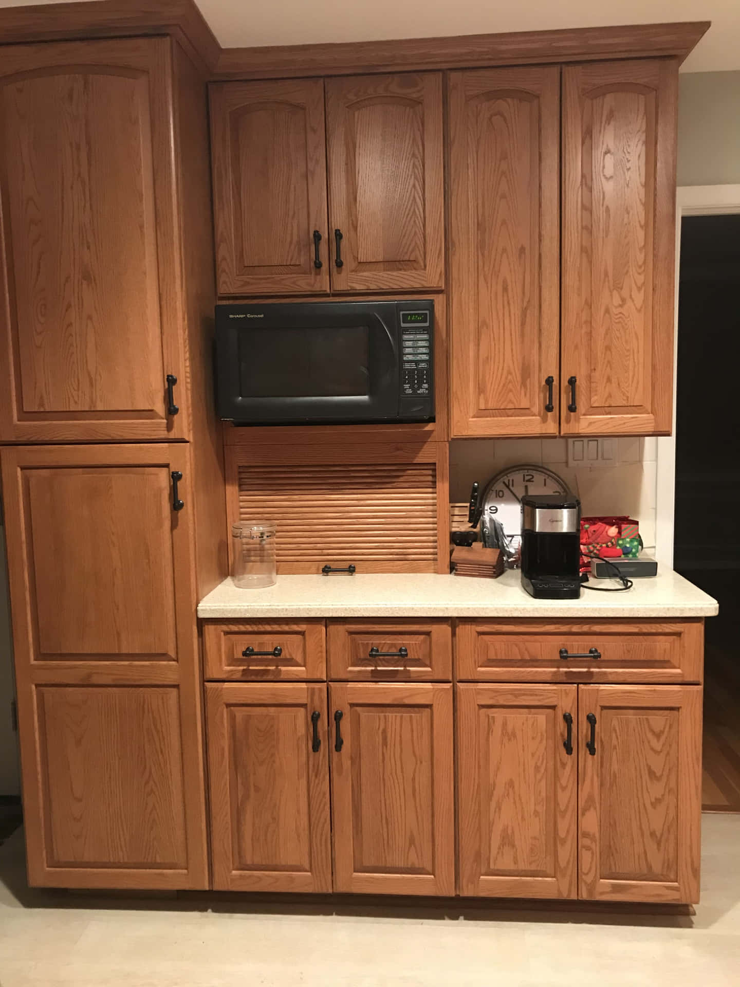 A Kitchen With Wood Cabinets And A Microwave