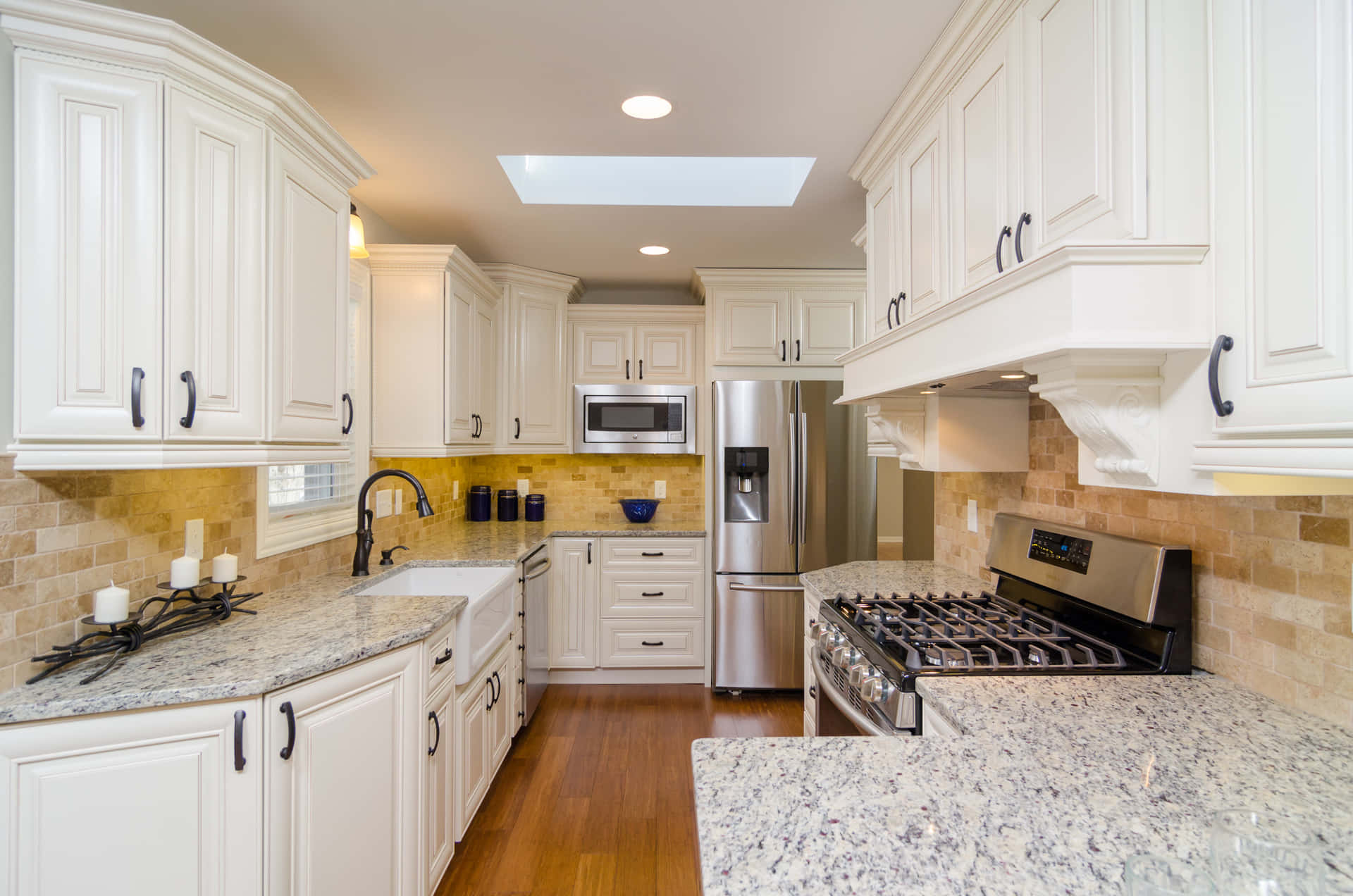 A Kitchen With White Cabinets And Granite Counter Tops
