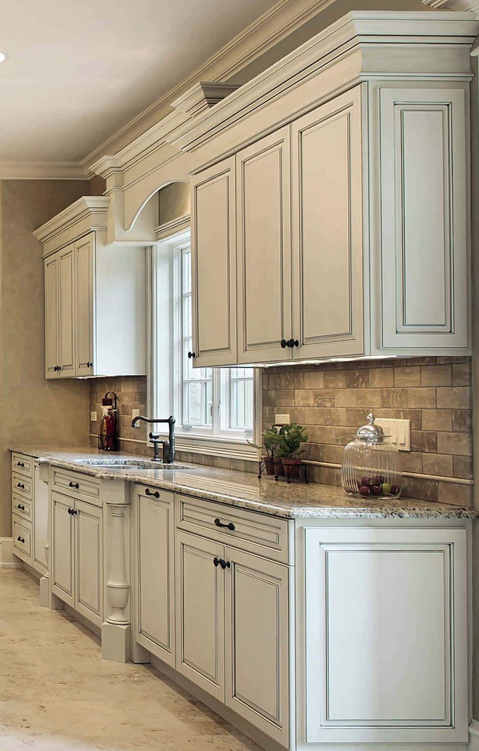 A Kitchen With White Cabinets And Marble Floors