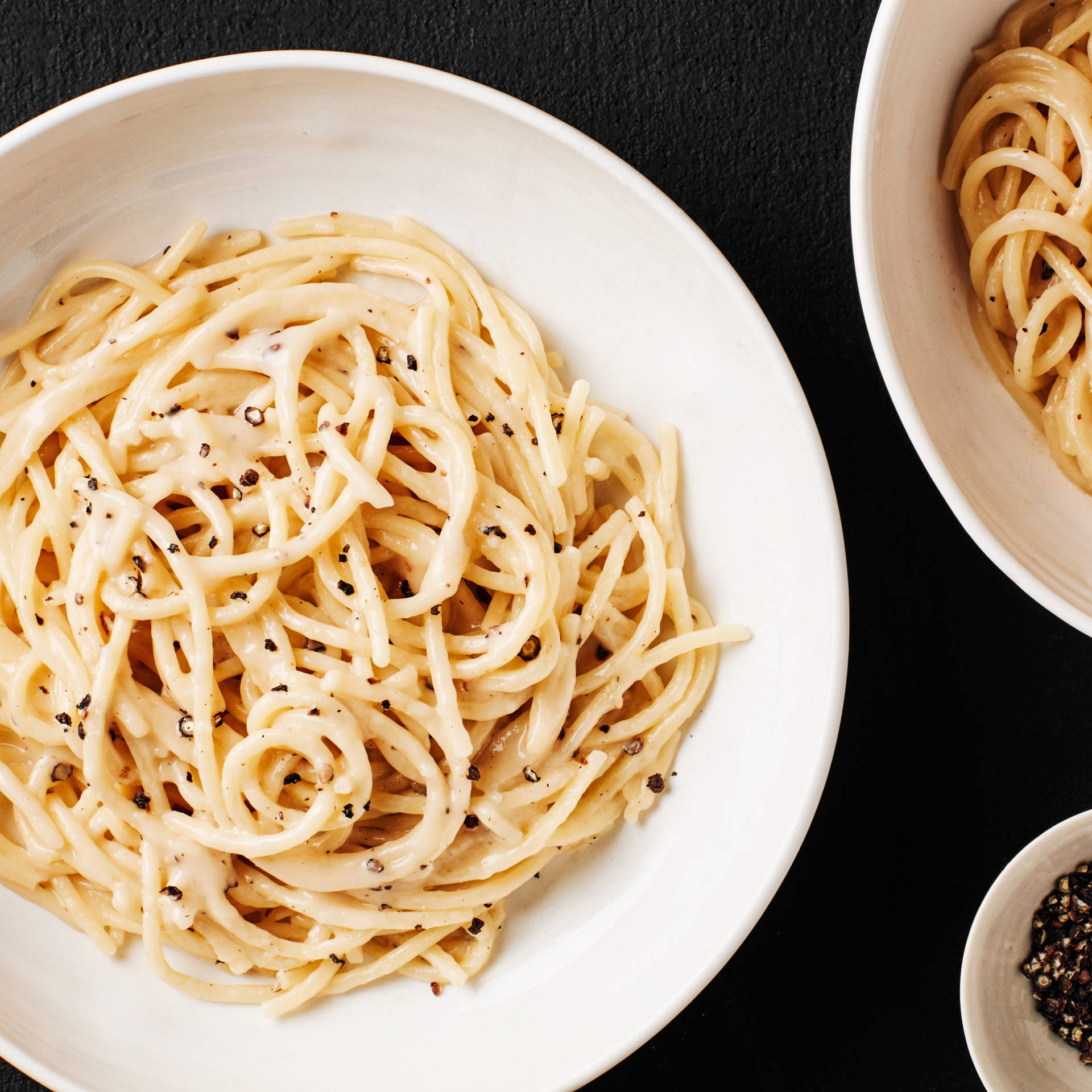 Delicious Bowl of Cacio E Pepe with a Side of Ground Pepper Wallpaper