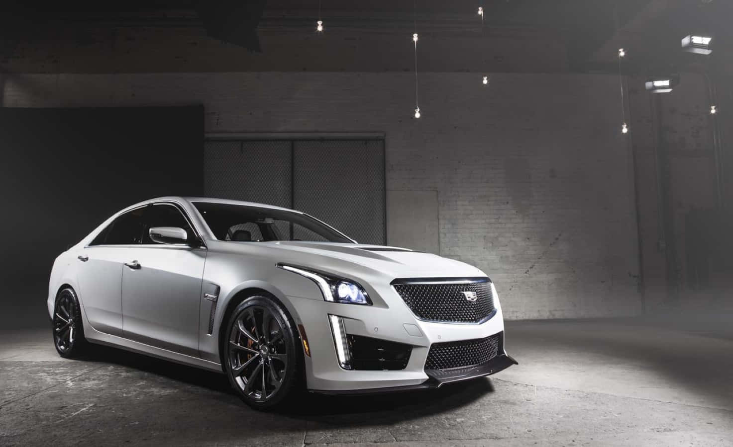 Sleek and Luxurious Cadillac CTS Standing Out on the Street in Nighttime Wallpaper