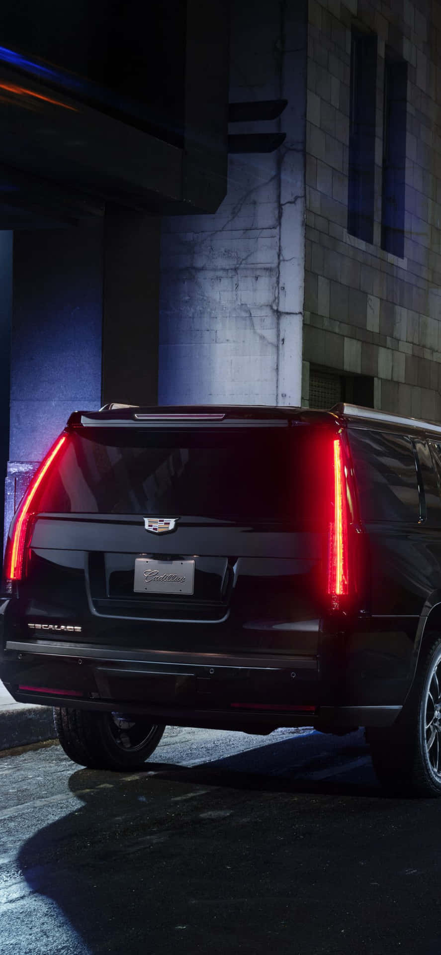 A luxurious Cadillac Escalade in a stunning cityscape Wallpaper