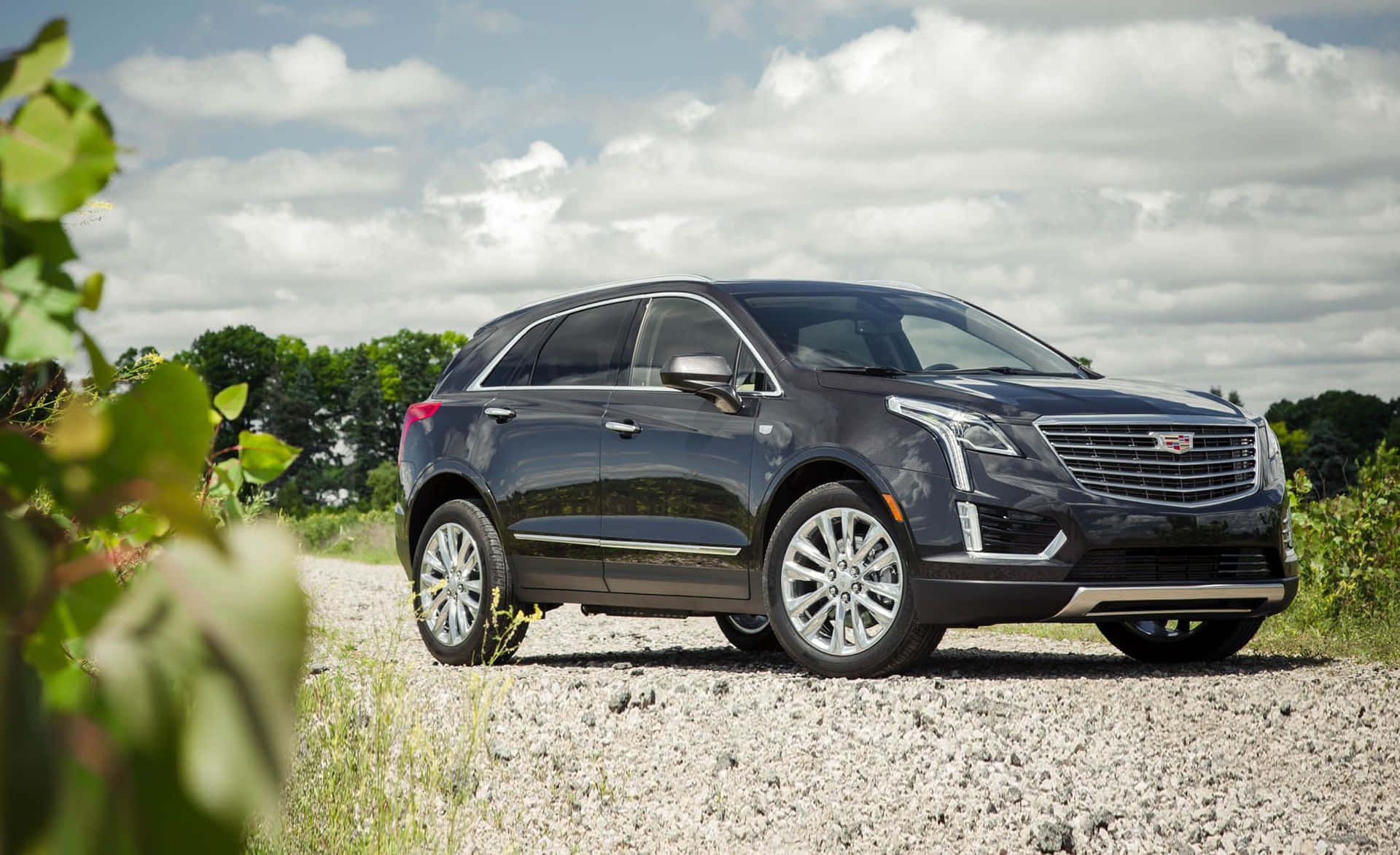 Sleek and Luxurious Cadillac XT5 SUV on Scenic Mountain Road Wallpaper