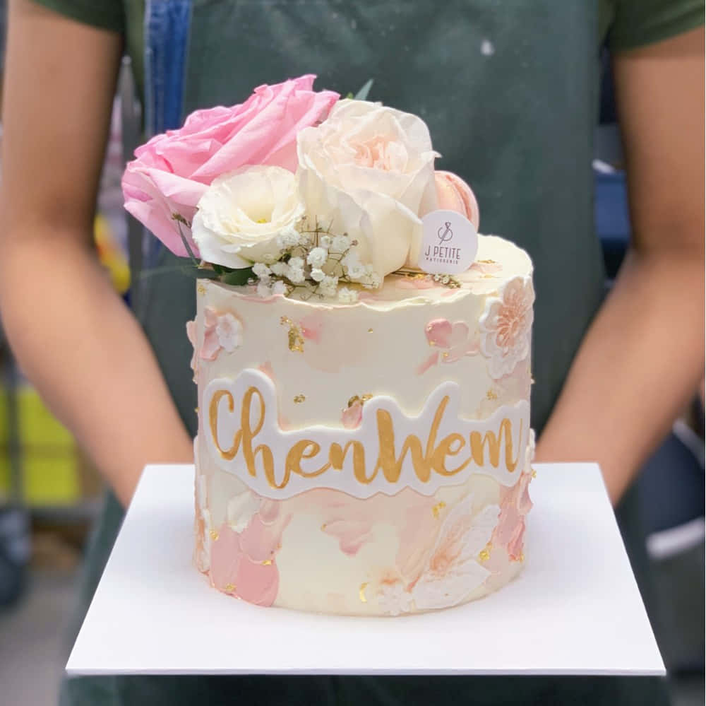 A Three-Tier White and Pink Cake Covered in Fondant Wallpaper