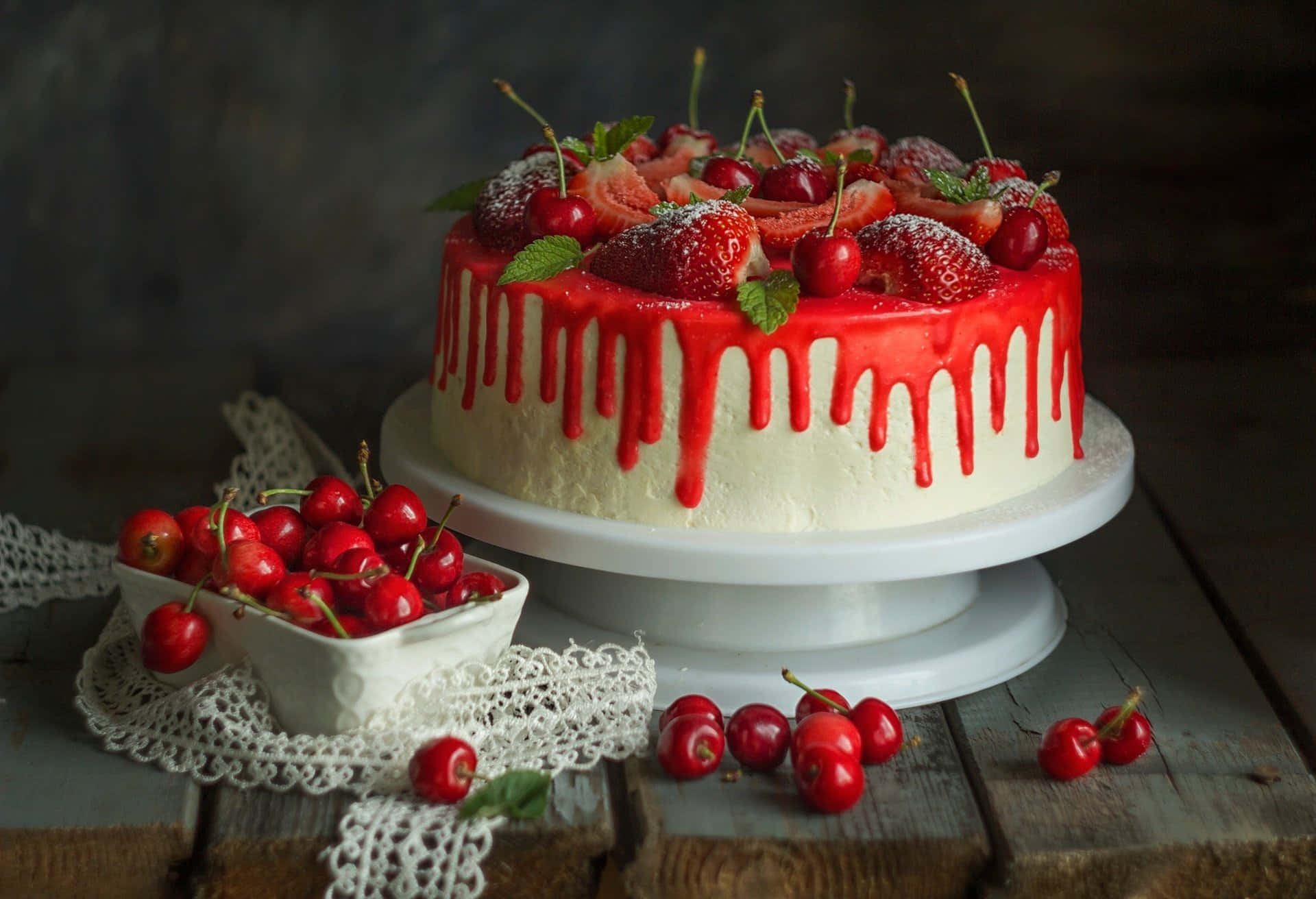 A Cake With Red Icing And Cherries On Top