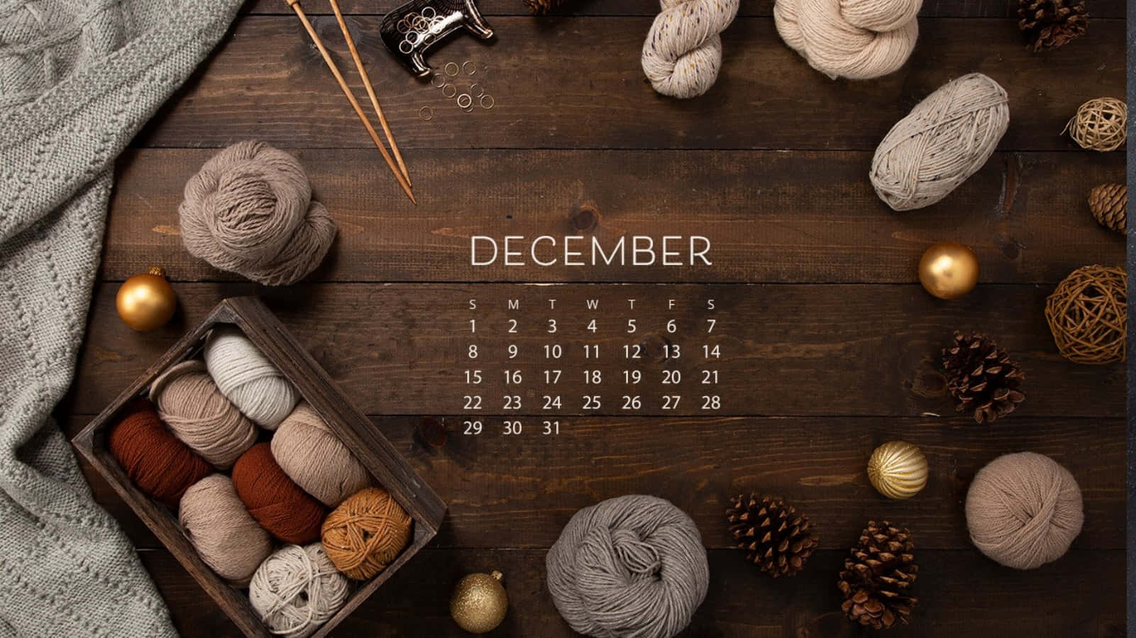 A Calendar With Knitting And Yarn On A Wooden Table