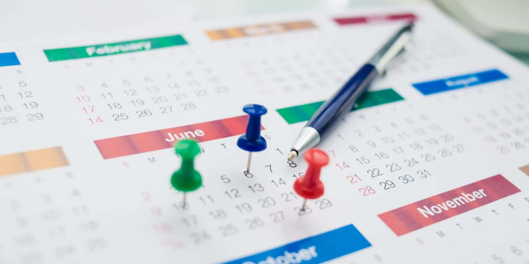 A Calendar With Colored Pins On It