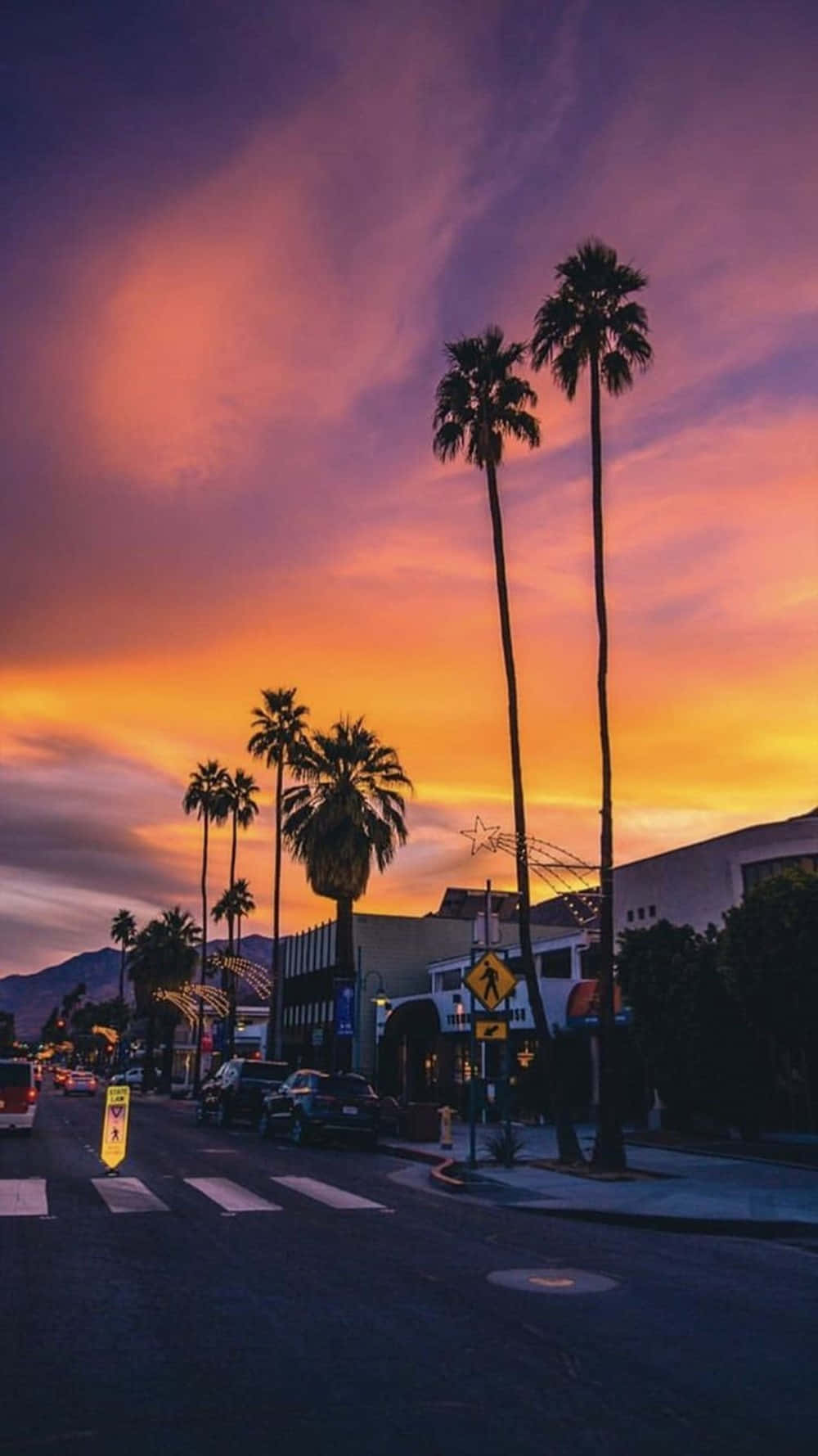 A Street With Palm Trees And A Sunset Wallpaper