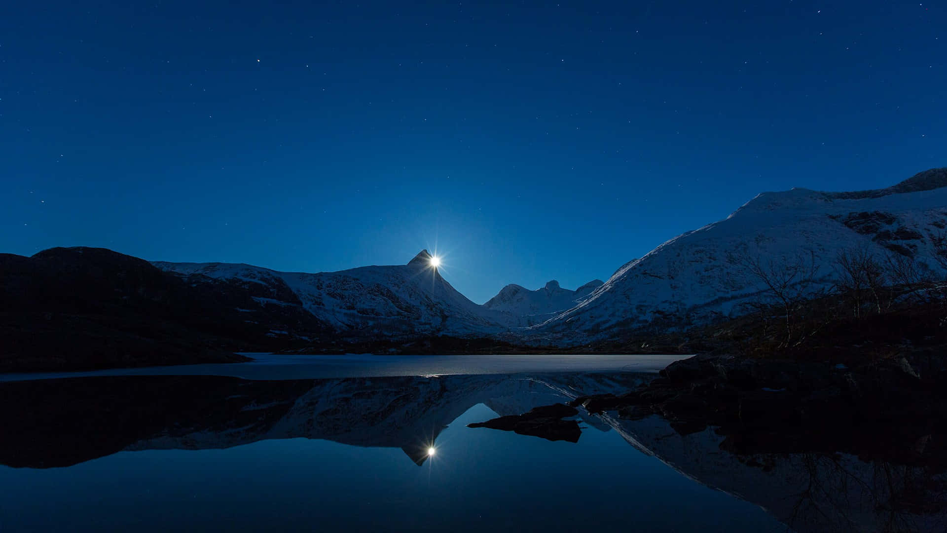 A Full Moon Is Seen Over A Lake At Night