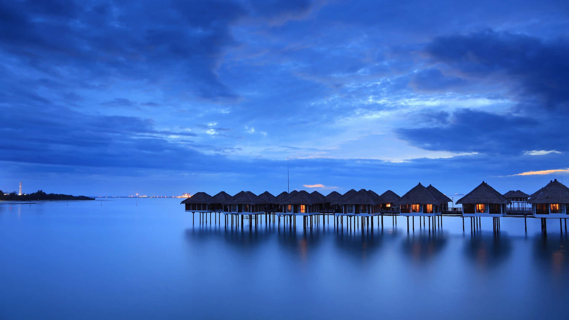A Group Of Huts On A Dock In The Water