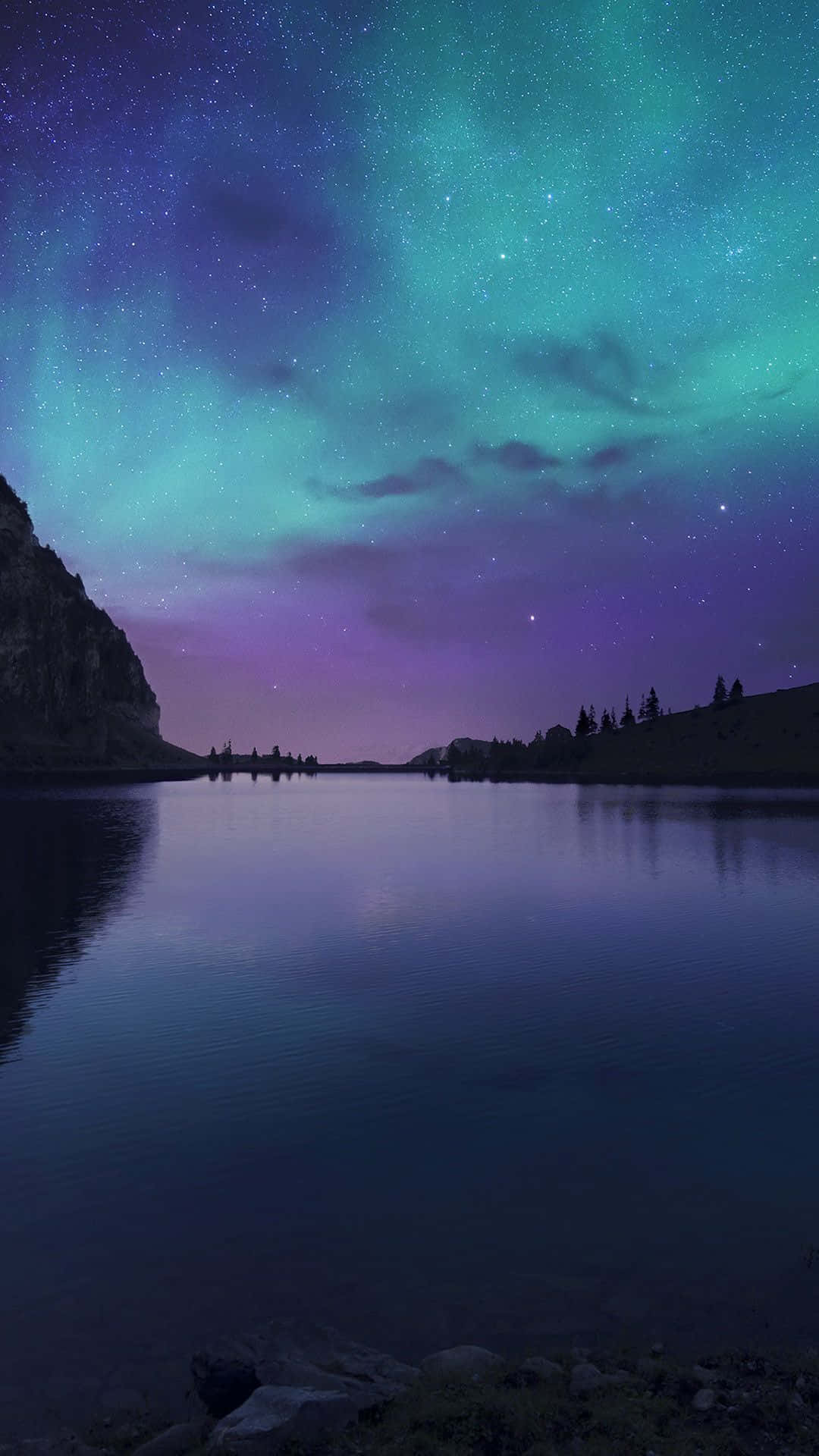 The Aurora Bore Over A Lake With Mountains In The Background Wallpaper