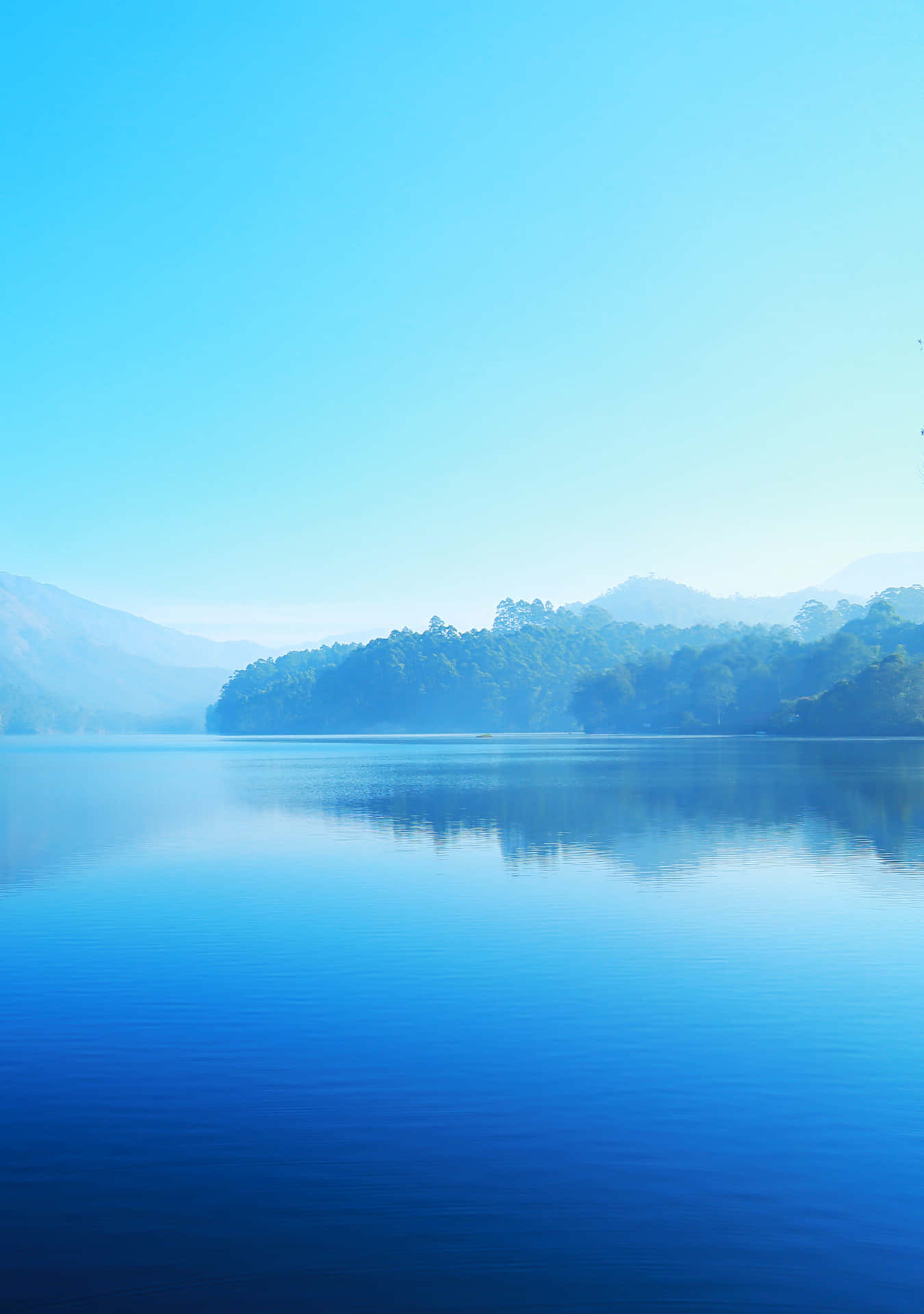 A Lake With Trees And Mountains In The Background Wallpaper