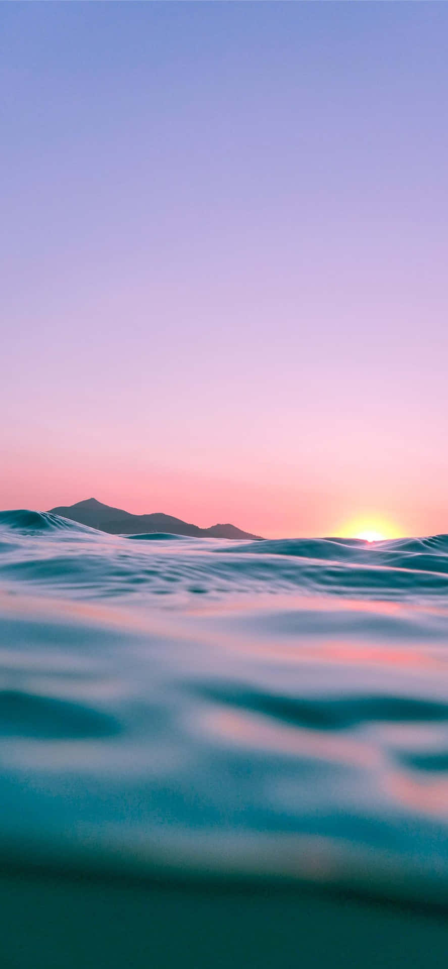 Einsonnenuntergang Über Dem Ozean Mit Wellen Und Bergen Wallpaper