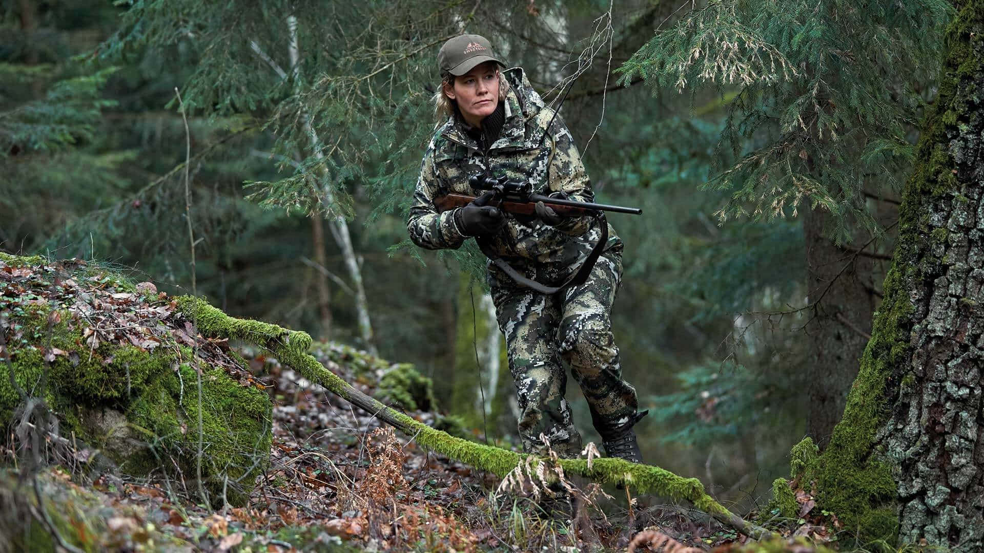 En mand i camouflage går gennem skovene