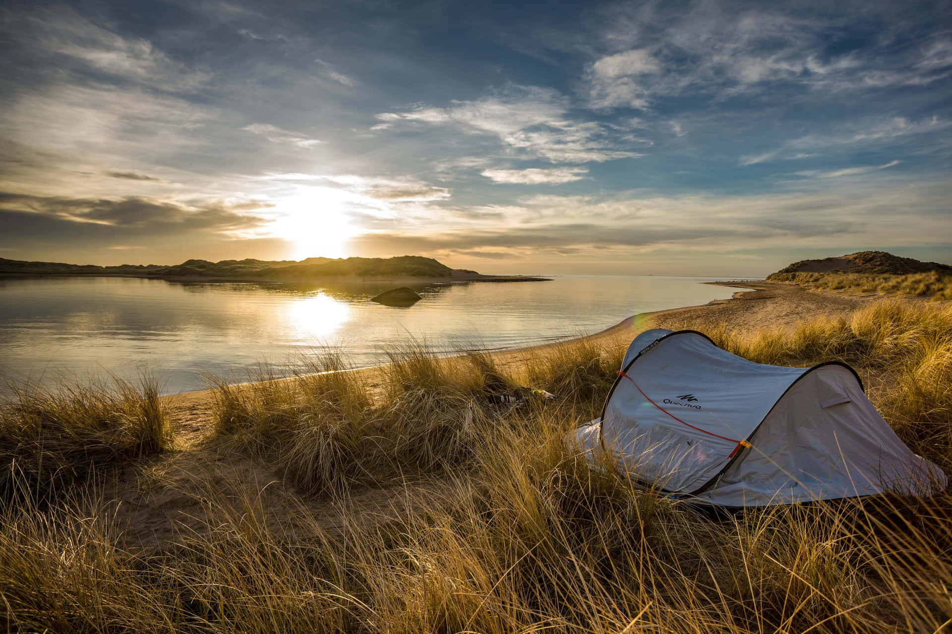 "A beautiful sunrise over a peaceful lakeside campsite"
