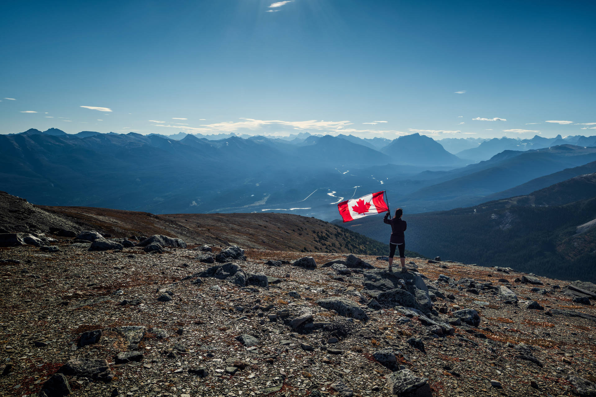 Canadian Flag And Person On Mountain Wallpaper