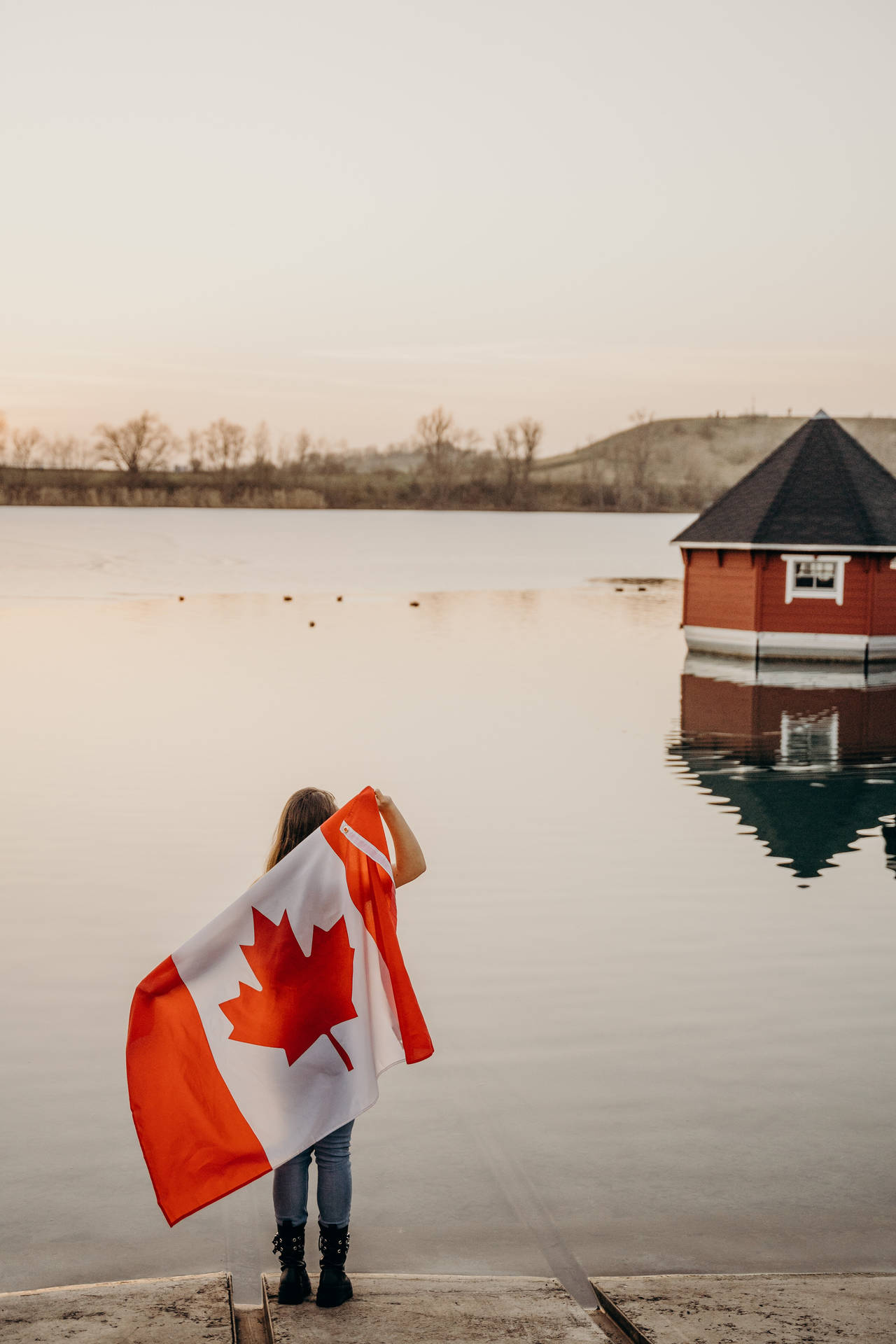 Holdingflag Lake: Lago Con Una Persona Sosteniendo La Bandera Canadiense. Fondo de pantalla