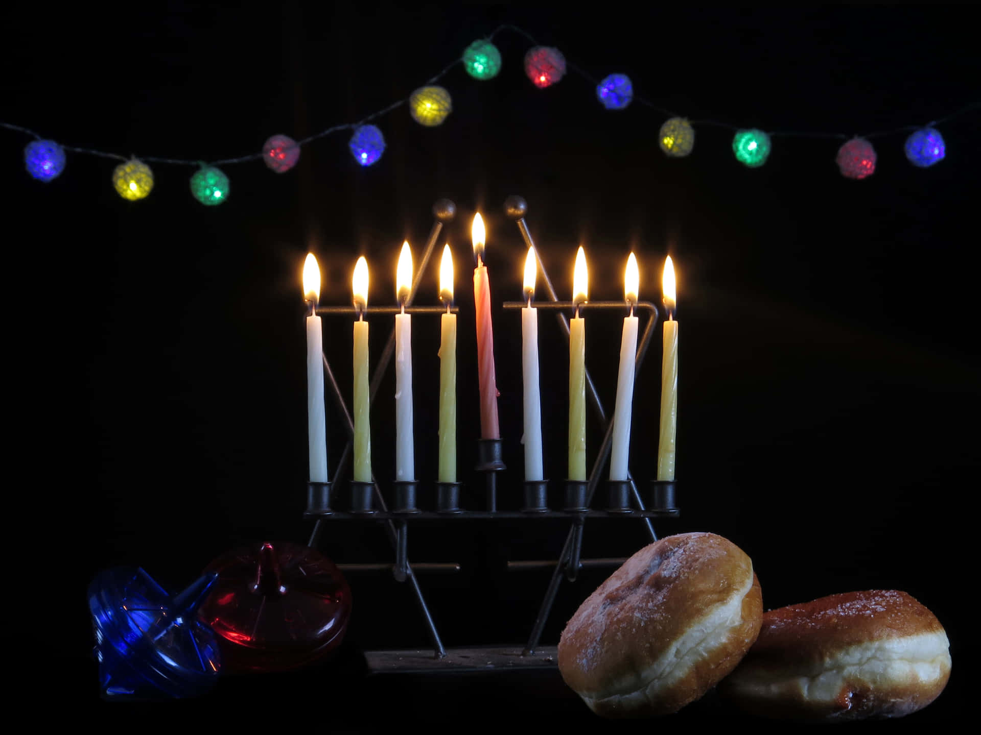 A Menorah With Candles And Donuts