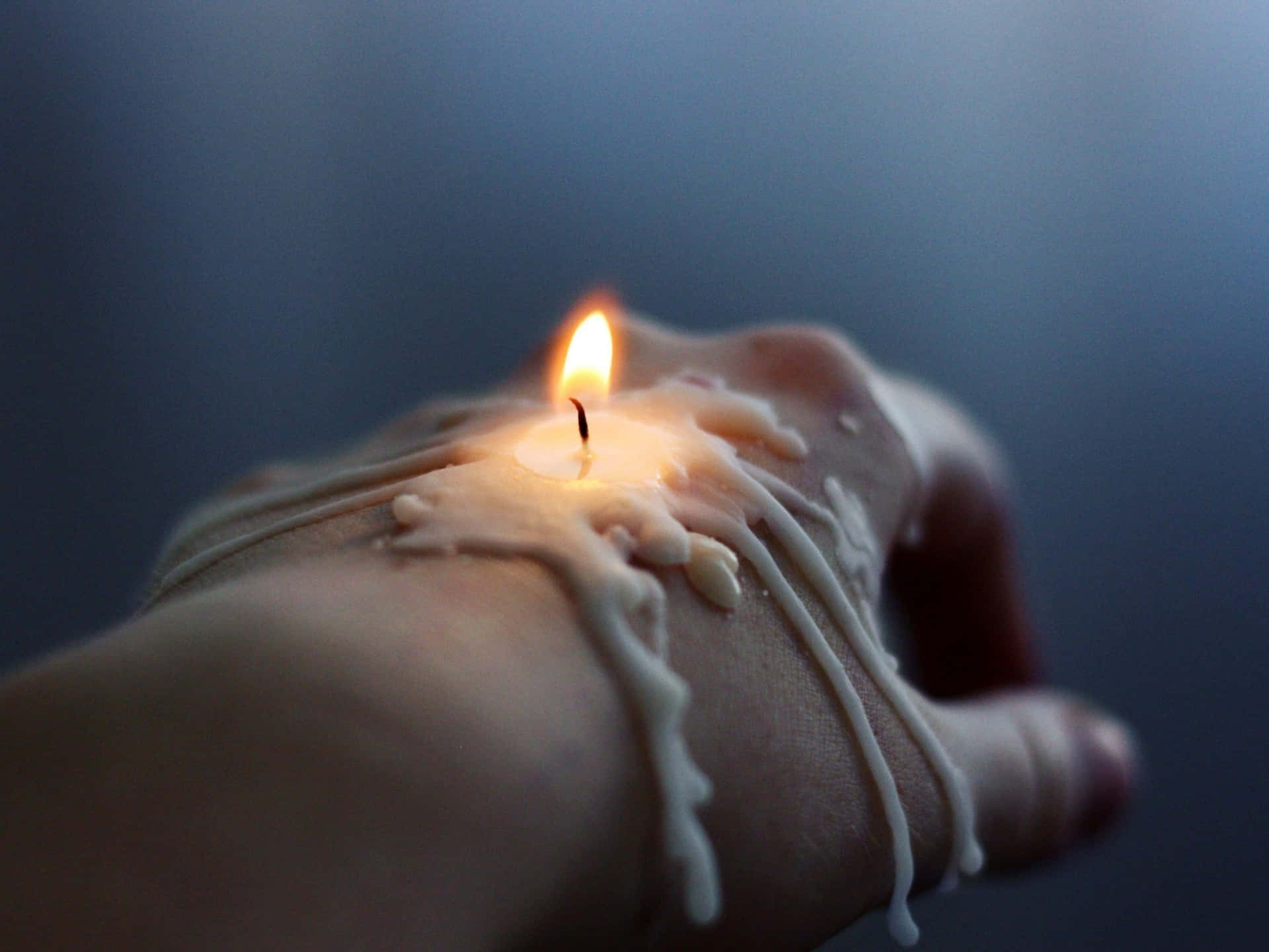 A Person's Hand With A Candle On It