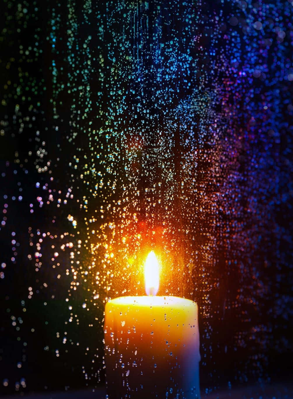 A Candle Is Lit In Front Of A Window With Rain Drops