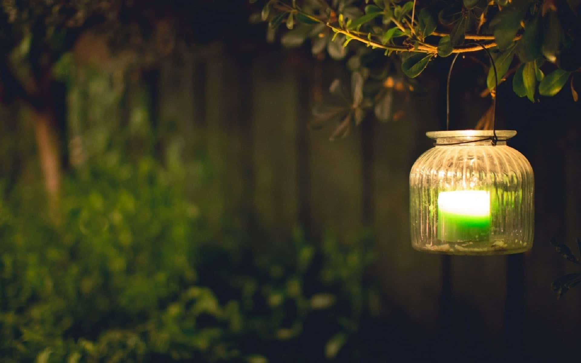 A Green Candle Hanging From A Lantern