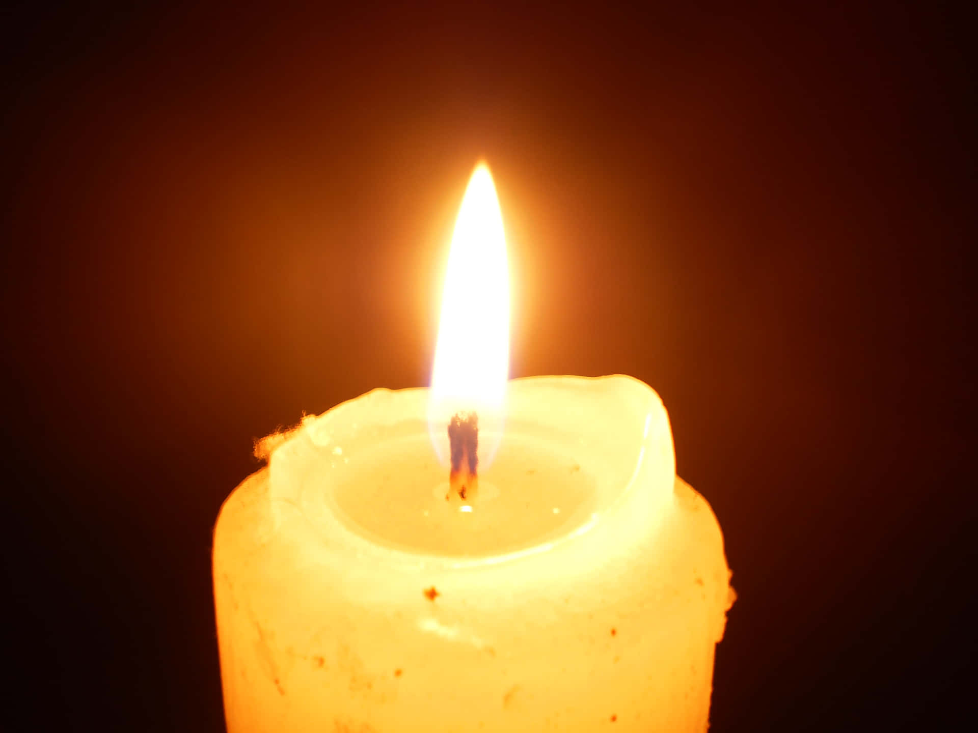 A Candle Is Lit On A Black Background